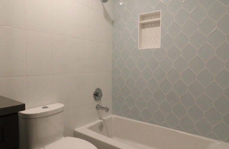 Image of complete hall bathroom remodel with tiled tub surround and floor